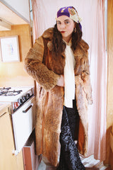 Women's vintage 1960's Apropos, Made in Korea label long sleeve knee length genuine fur coat with burnt orange leather trim and a tie belt.