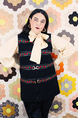 Women's vintage 1970's Palena Knitwear, Made in Hong Kong label sleeveless black wool vest with brass buckles closures up the front and floral trim details.