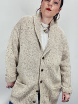 Men's vintage 1980's Rossan, Dongel Ireland, Hand Loomed in Ireland label long sleeve long length speckled cream colored button up cardigan with a rolled collar and brown buttons.