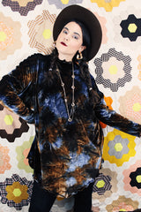 Long sleeve long length tie dye velvet top with a mock neck in a stretchy velvet material. Blue and brown colors with curly trim throughout.