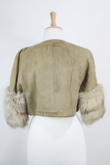 Women's vintage 1970's cropped fit tan suede jacket with short sleeves and two snap button closure in the front. Sleeves have a cream fur trim.