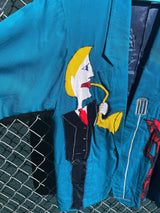 Women's vintage 1980's made in usa long sleeve blue blazer with one button closure and fully lined with large patches of people on front and back.