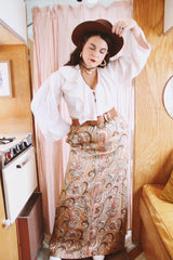 Women's vintage 1970's Saks Alley label long maxi length skirt in a tapestry material in orange colors and a paisley style print.