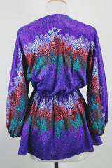 Women's vintage 1970's Cole of California label tie front blouse with balloon sleeves in purple, green, and orange colors and a lightweight polyester material.