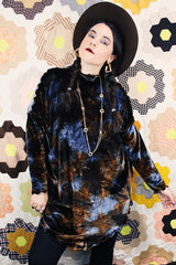 Long sleeve long length tie dye velvet top with a mock neck in a stretchy velvet material. Blue and brown colors with curly trim throughout.
