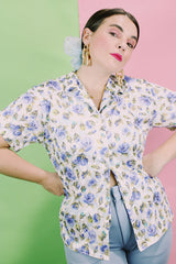 Women's vintage 1980's LORI by AM Casuals short sleeve button up blouse in white with all over blue floral print. Stretchy polyester material.