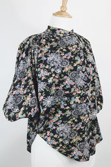 Women's vintage 1970's lightweight polyester material black blouse with all over multicolored ditsy floral print. Buttons up the front and has big wing sleeves.