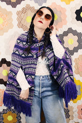 Women's vintage 1970's Made in Guatemala label purple and white printed poncho with fringe trim and two button closure across chest.