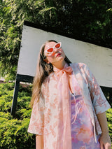 Women's vintage 1970's open front silver metallic blouse with short sleeves and all over white and pink rose floral print.