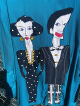 Women's vintage 1980's made in usa long sleeve blue blazer with one button closure and fully lined with large patches of people on front and back.