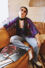 Women's vintage 1970's Cole of California label tie front blouse with balloon sleeves in purple, green, and orange colors and a lightweight polyester material.