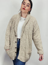 Men's vintage 1980's Rossan, Dongel Ireland, Hand Loomed in Ireland label long sleeve long length speckled cream colored button up cardigan with a rolled collar and brown buttons.