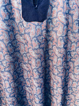 Women's or men's vintage 1970's long sleeve navy blue t-shirt with a paisley print on the front, a rounded dagger collar, and white popper buttons.