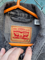 Women's Levi's black grey wash long sleeve button up lightweight jacket with brass hardware and pockets.