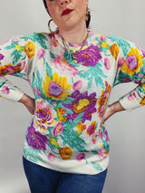 Women's vintage 1980's Sweater Teas label long sleeve white pullover acrylic sweater with all over large floral print in purple, yellow, and green.