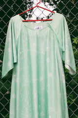 Women's vintage 1970's Butterfield 8, Made in USA label bell sleeved maxi length dress in light pastel green with Hawaiian floral print on the hem.