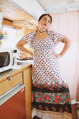 Women's vintage 1970's maxi length dress with flutter sleeves in white. Has an all over red and black ditsy floral print.