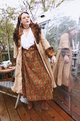 Women's vintage 1970's maxi length velvet skirt with an elastic waistband and matching tie belt. Orange with all over multicolored paisley print.