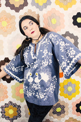 Women's vintage 1970's blue chambray tunic blouse with flared sleeves and a V shaped neckline. Has a white embroidered bird on the front.