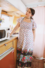 Women's vintage 1970's maxi length dress with flutter sleeves in white. Has an all over red and black ditsy floral print.