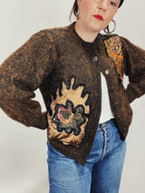 Women's vintage 1980's long sleeve brown orange wool cardigan with brass buttons and two abstract patches in the front.