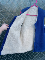 Men's or women's vintage 1970's sleeveless blue denim open front vest with cream shearling liner and pockets.
