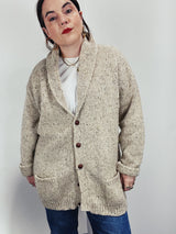 Men's vintage 1980's Rossan, Dongel Ireland, Hand Loomed in Ireland label long sleeve long length speckled cream colored button up cardigan with a rolled collar and brown buttons.