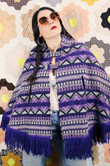 Women's vintage 1970's Made in Guatemala label purple and white printed poncho with fringe trim and two button closure across chest.