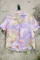 Women's vintage 1980's R&K Originals label short sleeve sheer button up blouse with all over purple and pink floral print with a slit in the back.
