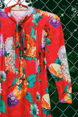 Women's vintage 1980's long sleeve mini dress with an attached tie neck. Red with all over floral print. Soft with shoulder pads.