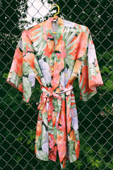 Women's vintage 1990's Val Mode Lingerie, Made in USA label short sleeve short length loungewear robe in an all over tropical floral print in orange and green with a matching tie belt.