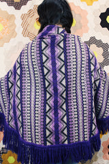 Women's vintage 1970's Made in Guatemala label purple and white printed poncho with fringe trim and two button closure across chest.
