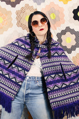Women's vintage 1970's Made in Guatemala label purple and white printed poncho with fringe trim and two button closure across chest.