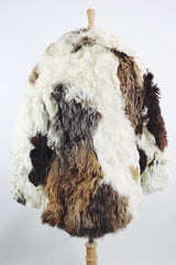 Women's vintage 1970's long sleeve genuine fur coat with double lapel in white with black and white patchwork details.