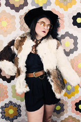 Women's vintage 1970's long sleeve genuine fur coat with double lapel in white with black and white patchwork details.