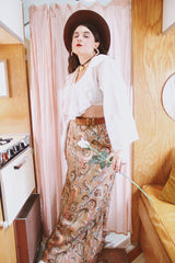 Women's vintage 1970's Saks Alley label long maxi length skirt in a tapestry material in orange colors and a paisley style print.