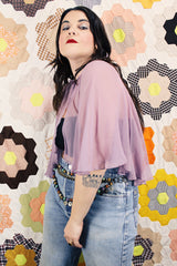 Women's vintage 1980's sheer silk material cape blouse in a light purple color. Has one hook and eye closure at neck with attached bow.