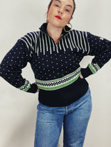 Women's vintage 1980's Demetre label long sleeve black pullover ski sweater with a half zip closure and white and green print all over.