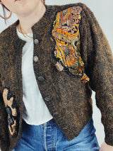 Women's vintage 1980's long sleeve brown orange wool cardigan with brass buttons and two abstract patches in the front.