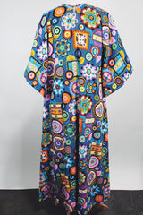 Women's vintage 1970's cotton material short sleeve maxi length dress with all over multicolored print. Has big flared sleeves and a V shaped neckline.