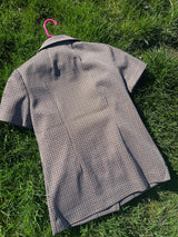 Women's vintage 1970's short sleeve button up shirt blouse in brown, white, and black gingham checkered polyester material with pockets.