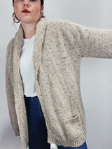 Men's vintage 1980's Rossan, Dongel Ireland, Hand Loomed in Ireland label long sleeve long length speckled cream colored button up cardigan with a rolled collar and brown buttons.