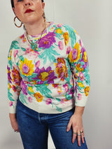 Women's vintage 1980's Sweater Teas label long sleeve white pullover acrylic sweater with all over large floral print in purple, yellow, and green.