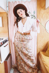 Women's vintage 1970's Saks Alley label long maxi length skirt in a tapestry material in orange colors and a paisley style print.