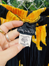 Women's vintage 1990's Anthony Mark Hankins label midi length black skirt with all over bright yellow flower. Tight pleats throughout with a stretchy elastic waistband.