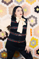 Women's vintage 1970's Palena Knitwear, Made in Hong Kong label sleeveless black wool vest with brass buckles closures up the front and floral trim details.