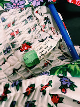 Women's vintage 1970's maxi length dress with flutter sleeves in white. Has an all over red and black ditsy floral print.