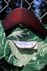 Men's vintage 1970's Grand Slam Munsignwear label short sleeve half button closure shirt with dagger collar in green with all over print. Polyester material.