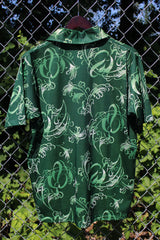 Men's vintage 1970's Grand Slam Munsignwear label short sleeve half button closure shirt with dagger collar in green with all over print. Polyester material.