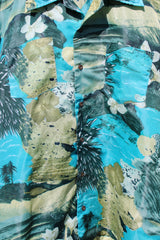 Men's vintage 1970's Waikiki Holiday label short sleeve button up Hawaiian print shirt with two chest pockets. Green and blue camera print in polyester material.